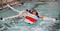 student paddling boat smiling