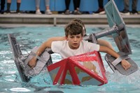 students paddling through water