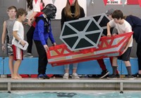 students carrying boat