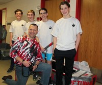 students standing next to boat with principal