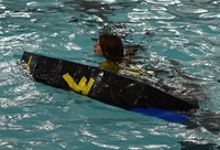 student next to boat in water