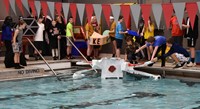 students putting boats in the water