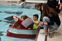 students sitting in boat