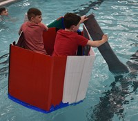 two students paddling in boat