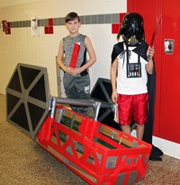 two additional students standing next to boat