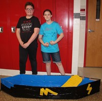 two more students standing next to boat