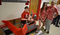 three students next to boat