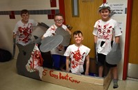 four students next to boat