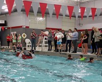 wide shot of students paddling in boat