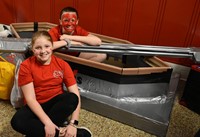 two students next to boat