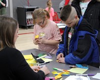 two students and adult at steam night station