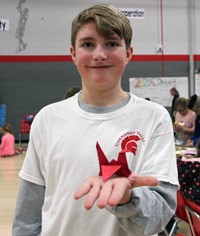 student holding origami item