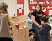 students watching rube goldberg machine