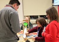 students and educator working with rube goldberg machine