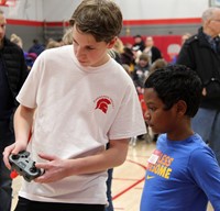 two students working with robotics station