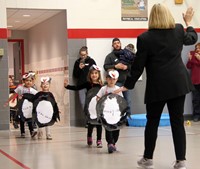 students and teacher walking in penguin parade