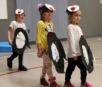 three students in penguin parade