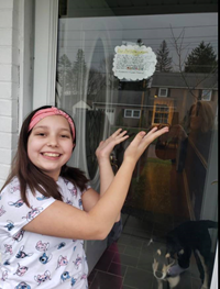 student holding up thank you sign in window