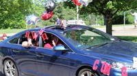 senior in parade smiling and waving