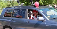 senior in parade smiling and waving