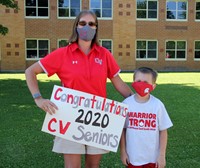 teacher and son holding signs at parade