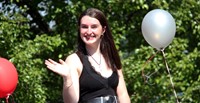 student in parade smiling