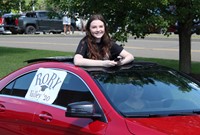 student in parade smiling