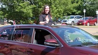 student in parade smiling