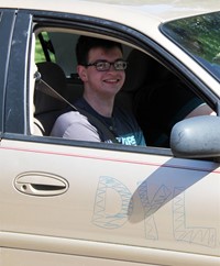 student in parade smiling and waving