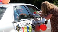 student in parade receiving flower