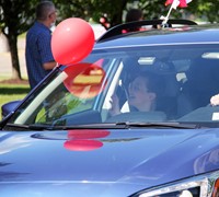 student in parade waving