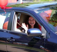 teachers waving to students in cars