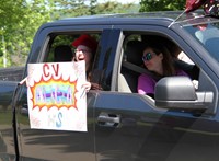 student in parade smiling and waving