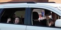 student waving in car