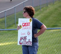 teacher holding sign