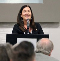 Dr. Megan Conklin Pecha speaking at podium