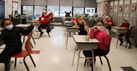 students holding up shoes they created as part of social-emotional learning lesson