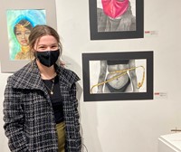 additional student at Emerging Artists Exhibit next to artwork