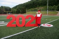 student standing next to 2021 sign