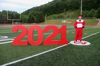 student standing next to 2021 sign