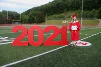 student standing next to 2021 sign