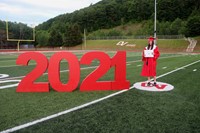 student standing next to 2021 sign