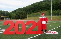 student standing next to 2021 sign