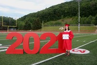 student standing next to 2021 sign