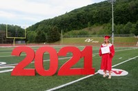 student standing next to 2021 sign