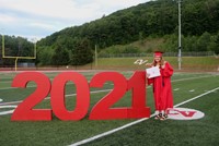 student standing next to 2021 sign