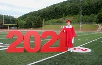 student standing next to 2021 sign