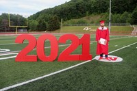 student standing next to 2021 sign