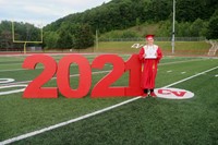 student standing next to 2021 sign