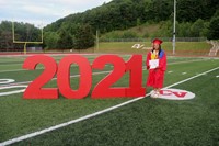 student standing next to 2021 sign